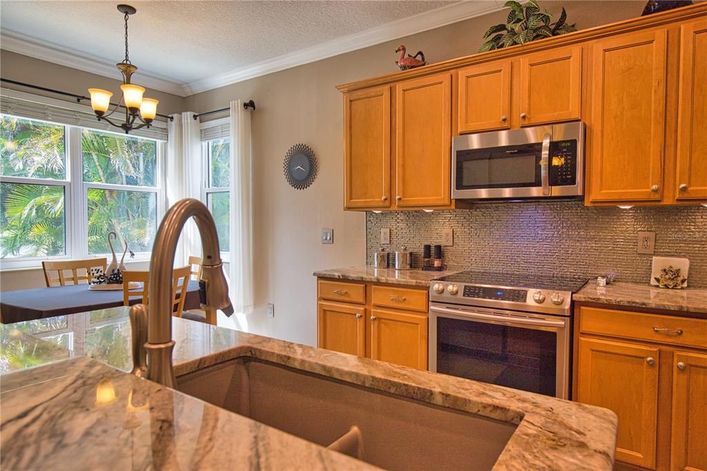 5288 Layton Drive Venice, FL 34293 - Photo 22 of 75 a kitchen with stainless steel appliances granite countertop a stove a sink and a microwave