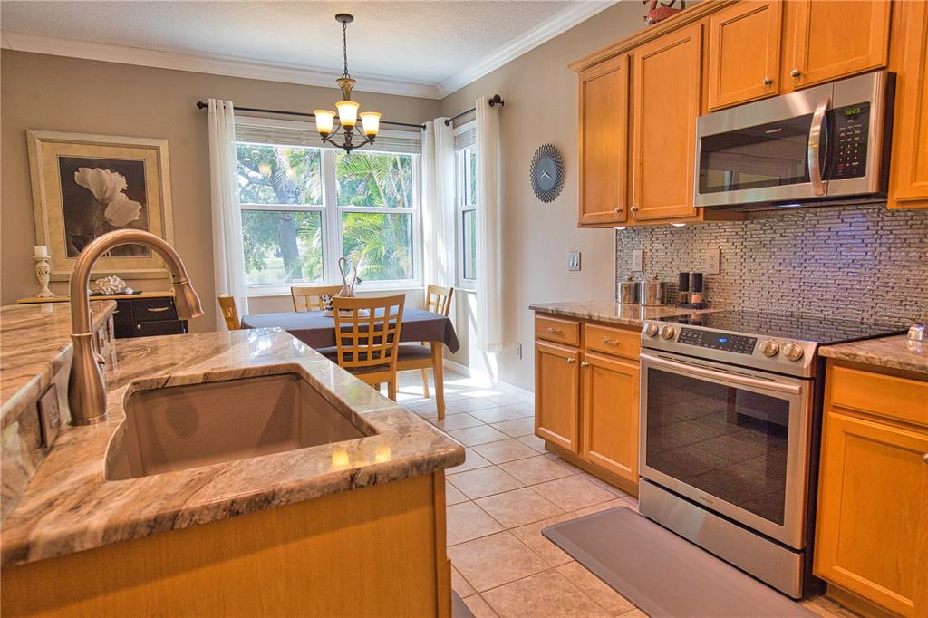5288 Layton Drive Venice, FL 34293 - Photo 24 of 75 a kitchen with a stove a sink and a microwave