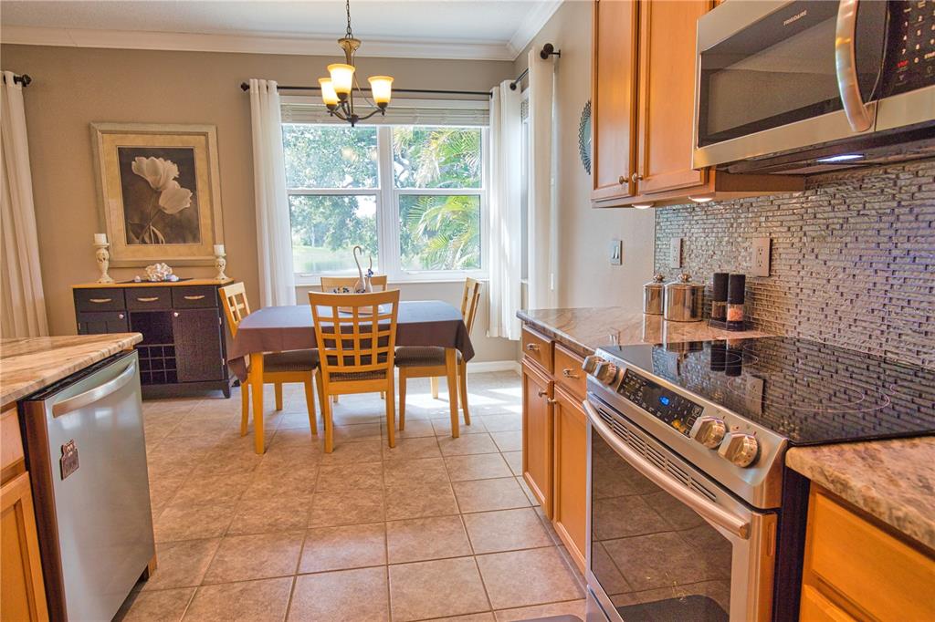 5288 Layton Drive Venice, FL 34293 - Photo 26 of 75 a kitchen with stainless steel appliances granite countertop sink stove top oven and cabinets
