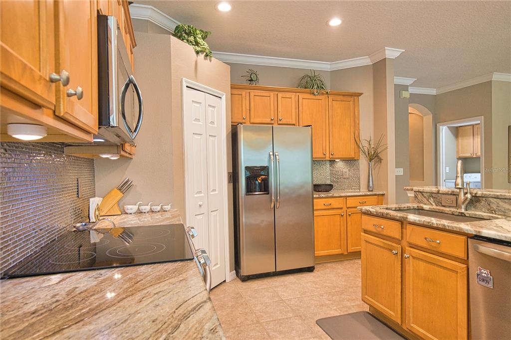 5288 Layton Drive Venice, FL 34293 - Photo 27 of 75 a kitchen with stainless steel appliances granite countertop a refrigerator a stove and a sink with wooden floor