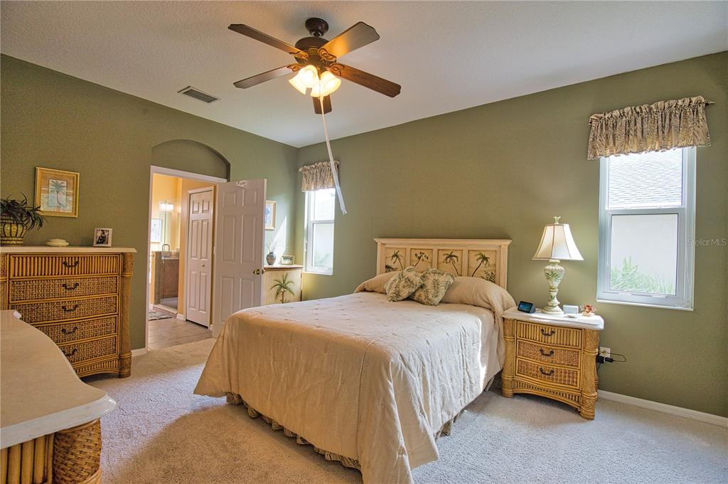5288 Layton Drive Venice, FL 34293 - Photo 32 of 75 a bedroom with a bed a chandelier and a dresser