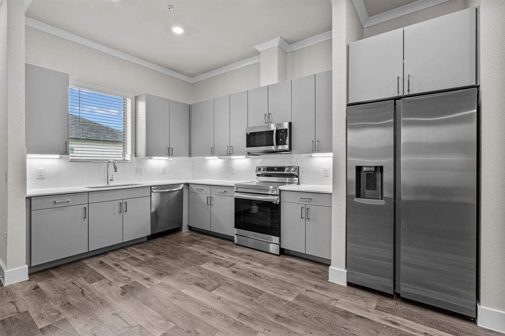 3281 Ganzer Road West, Unit 817A Denton, TX 76207 - Photo 7 of 40 a kitchen with a refrigerator a sink and a stove top oven