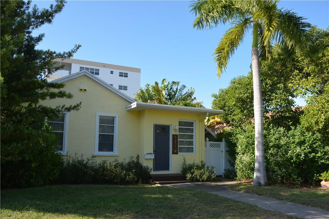 a front view of a house with a garden and trees