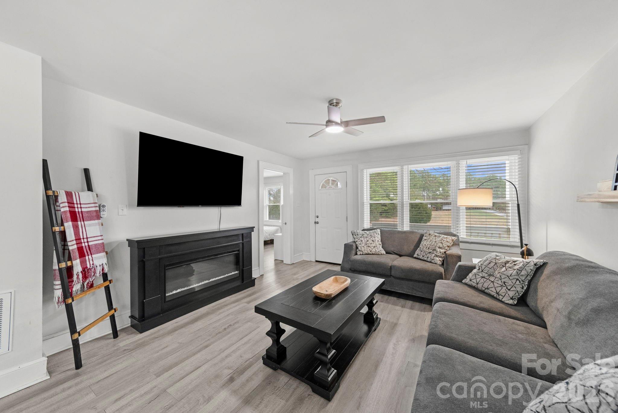 36141 Palestine Road Albemarle, NC 28001 - Photo 5 of 40 a living room with furniture a flat screen tv and a fireplace