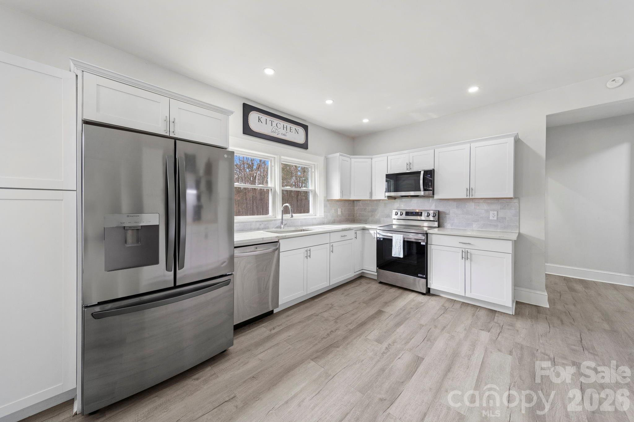 36141 Palestine Road Albemarle, NC 28001 - Photo 9 of 40 a kitchen with a refrigerator a sink and a stove top oven