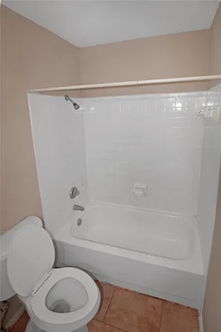 a white toilet and tub next to a shower