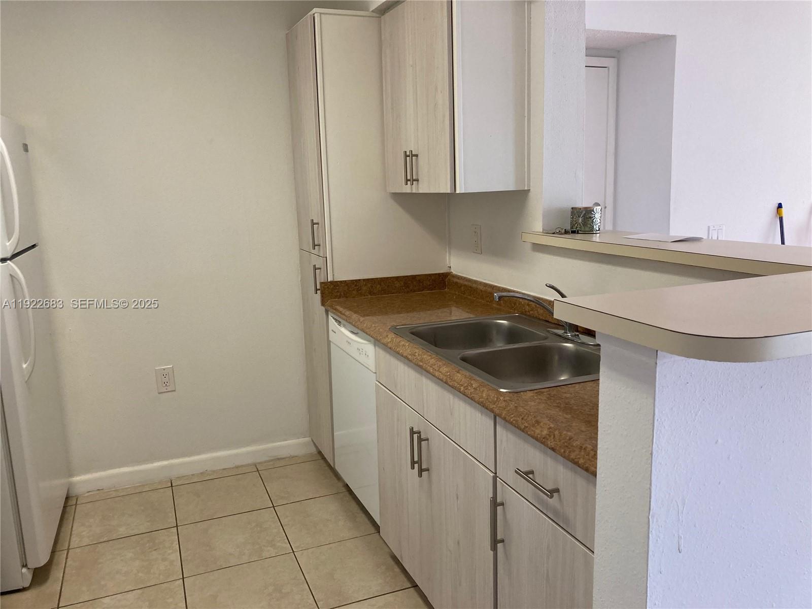 10360 Southwest 150th Court, Unit 12104 Miami, FL 33196 - Photo 3 of 23 a kitchen with a sink and cabinets