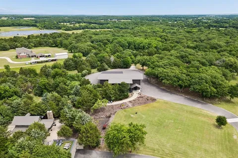 an aerial view of a house with a yard and lake view