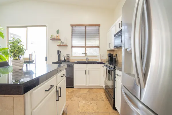 a kitchen with white cabinets and a window