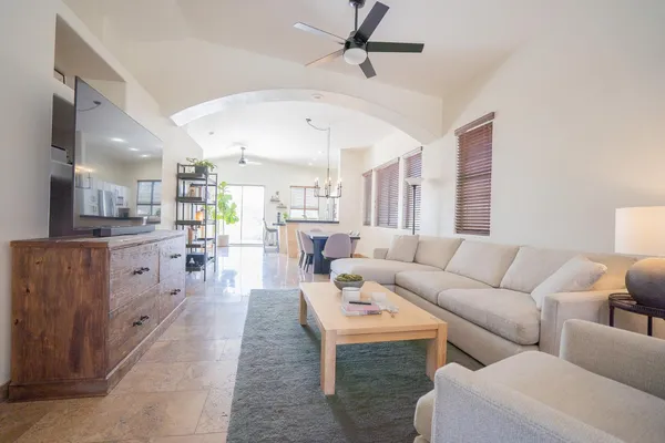 a living room with furniture and a view of kitchen