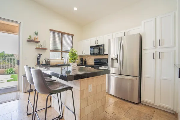 a kitchen with stainless steel appliances granite countertop a refrigerator and a stove top oven