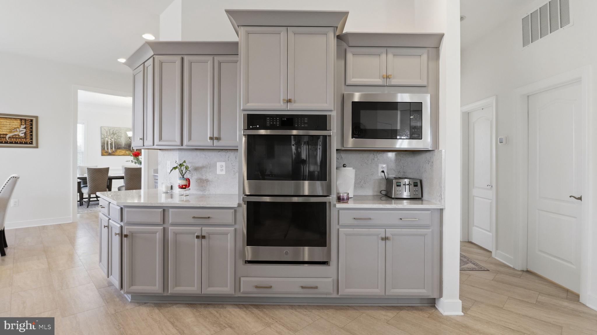 11502 Aden Road Nokesville, VA 20181 - Photo 39 of 106 a kitchen with stainless steel appliances granite countertop a stove a microwave and a white cabinets
