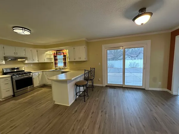 a kitchen with a sink and wooden floor