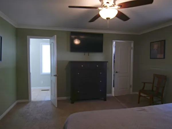 a spacious bedroom with a bed and a chandelier