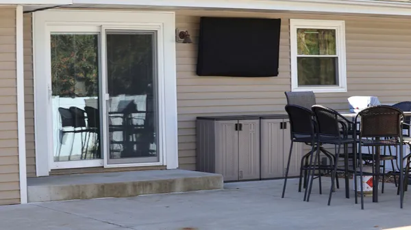 a view of a house with a chairs and table in a patio