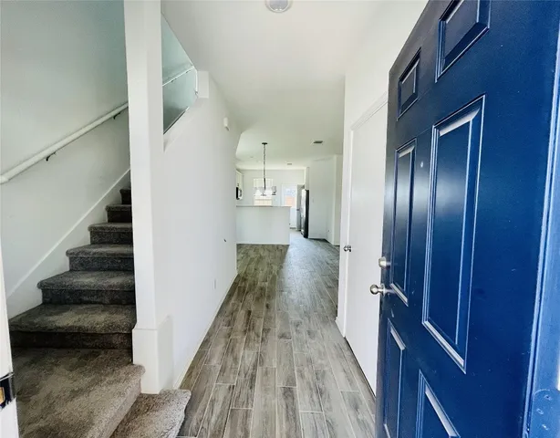 a view of a hallway with wooden floor and staircase