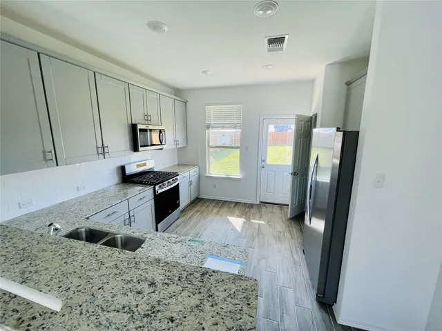 a kitchen with granite countertop a refrigerator and a sink