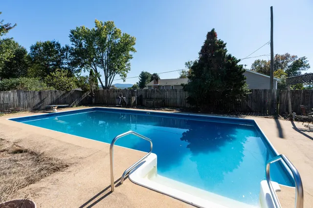 a view of a backyard with swimming pool