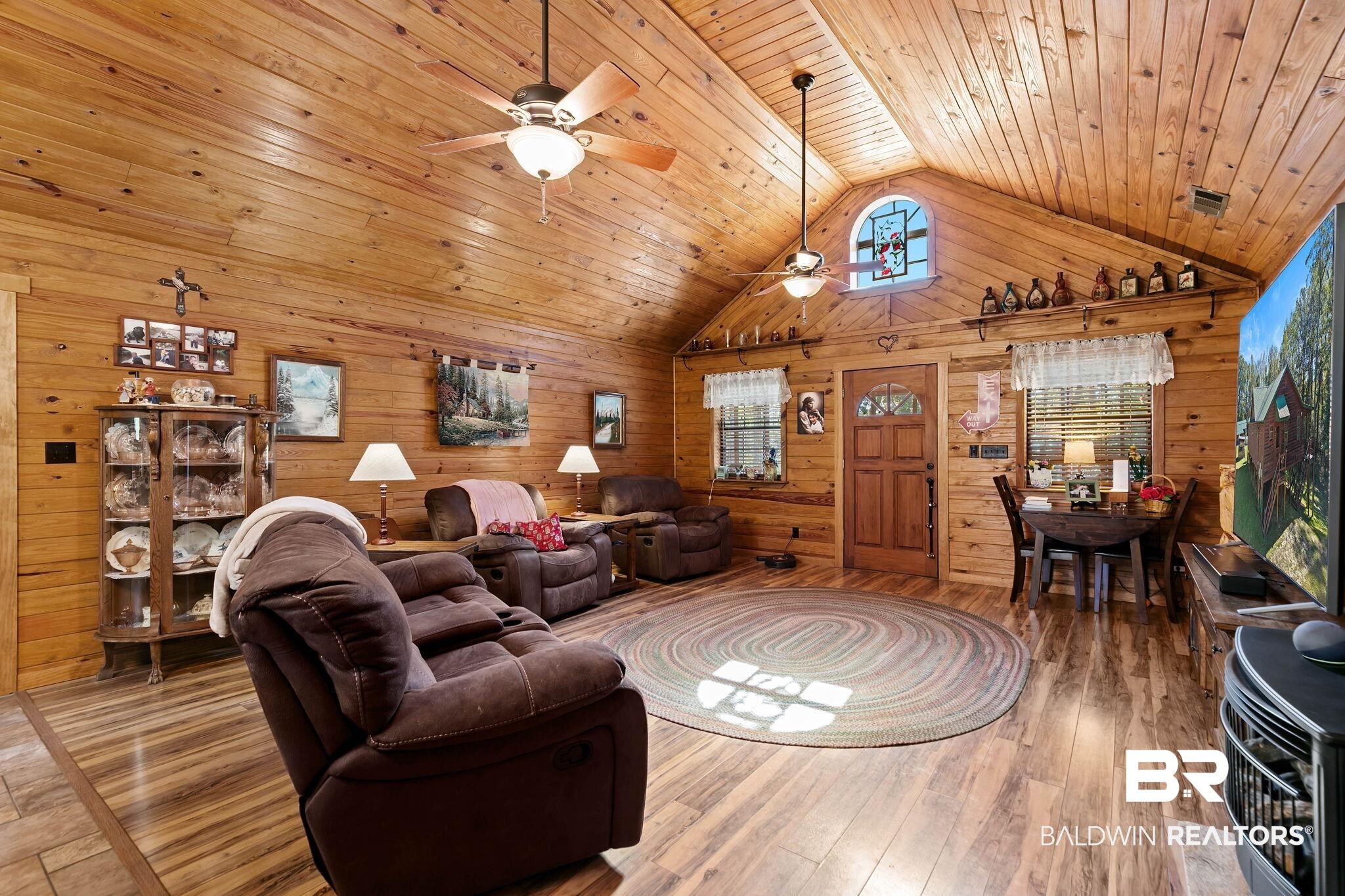 724 Rowell Lane Brewton, AL 36426 - Photo 12 of 40 Living area with high vaulted ceiling, wood-type flooring, wood walls, a ceiling fan, and wood ceiling