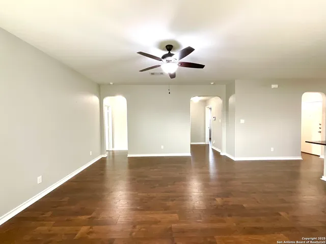 a view of an empty room and a ceiling fan