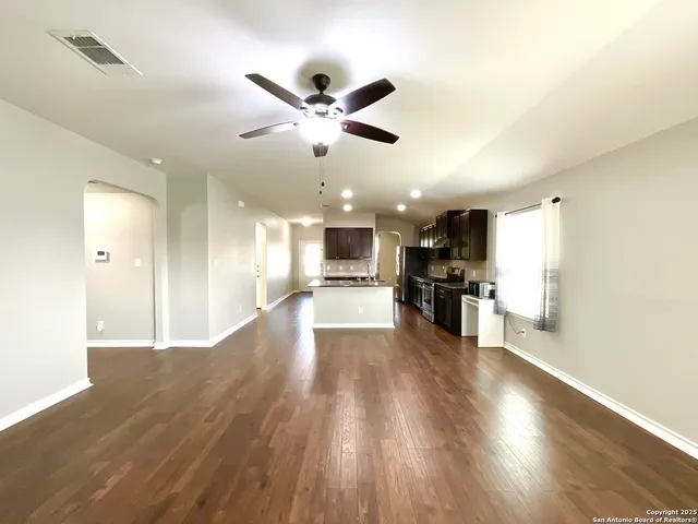 a view of an empty room and kitchen view