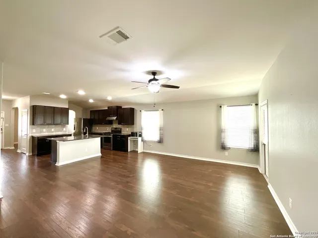 a view of a kitchen and dining room wooden floor a sink and a kitchen