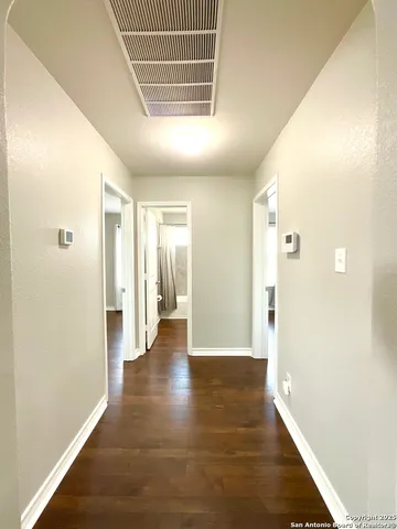 a view of a hallway with wooden floor