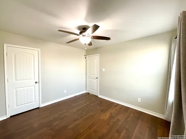 a view of an empty room with wooden floor