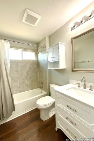 a bathroom with a sink a toilet a mirror and bathtub