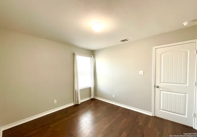 a view of an empty room with wooden floor