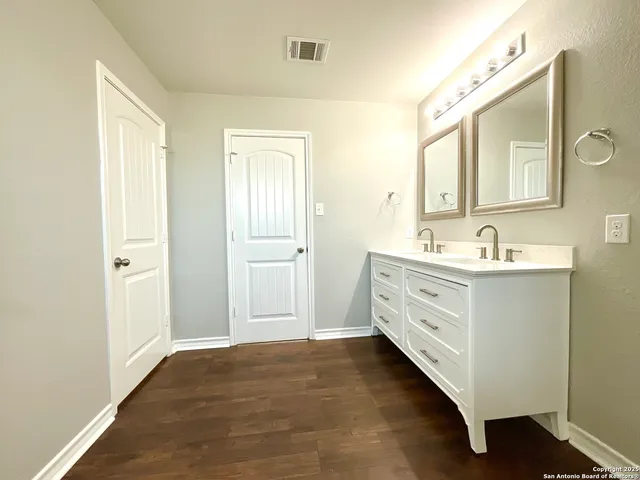 a bathroom with a double vanity sink mirror and