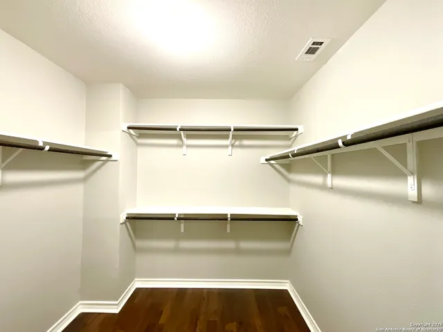 a view of walk in closet with empty racks