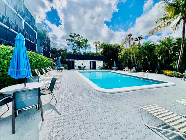 a view of a swimming pool with a lounge chair and potted plants