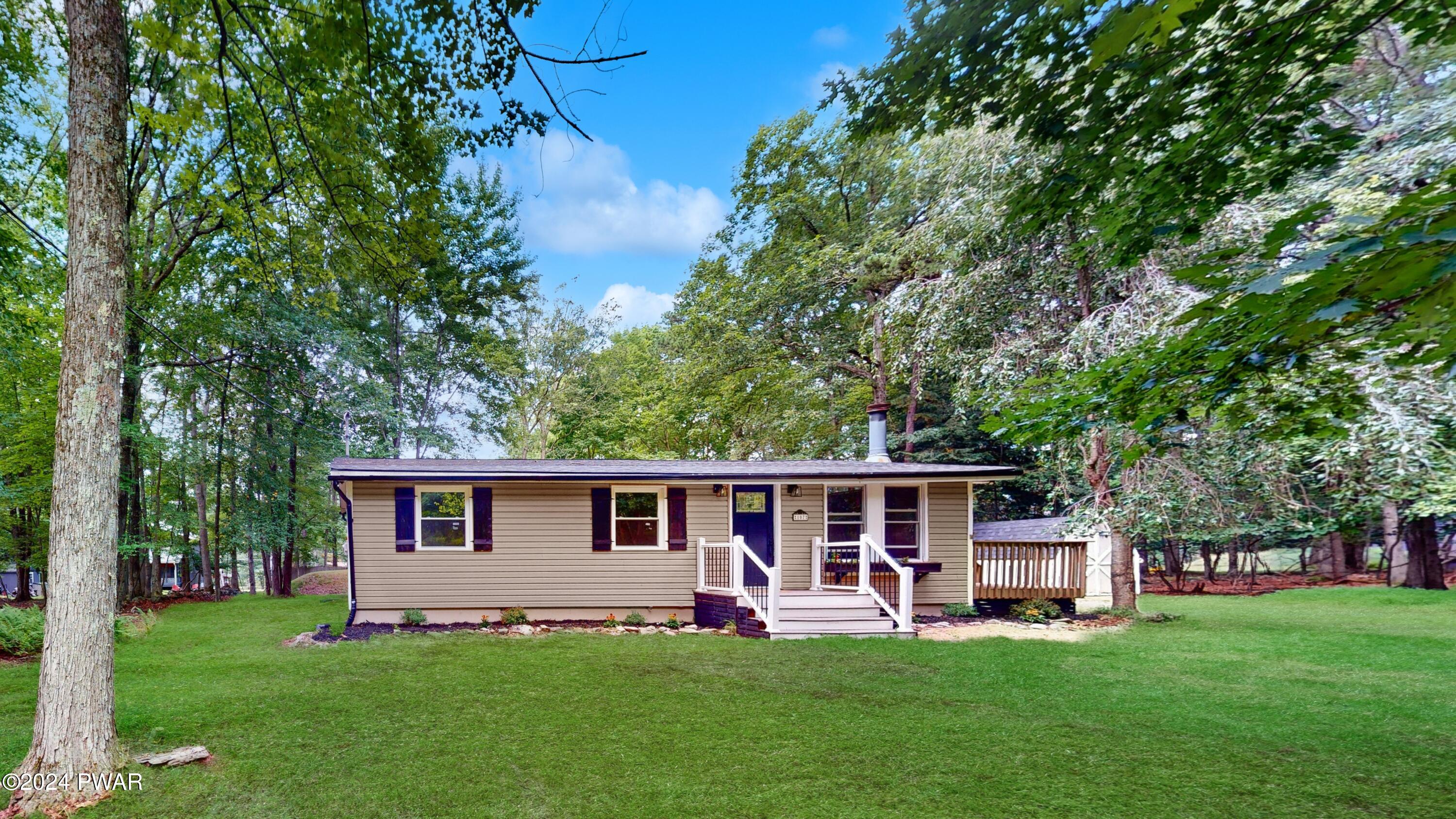 107 Hickory Road Milford, PA 18337 - Photo 1 of 39 a front view of a house with garden and trees