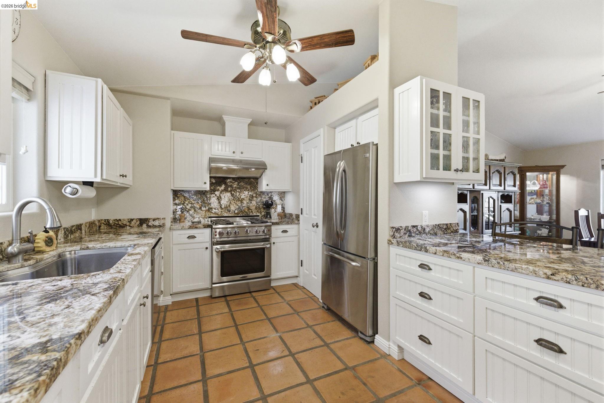 5356 Dogtown Road Coulterville, CA 95311 - Photo 28 of 60 a kitchen with granite countertop a sink stove refrigerator and cabinets