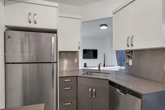 a kitchen with a refrigerator sink and cabinets