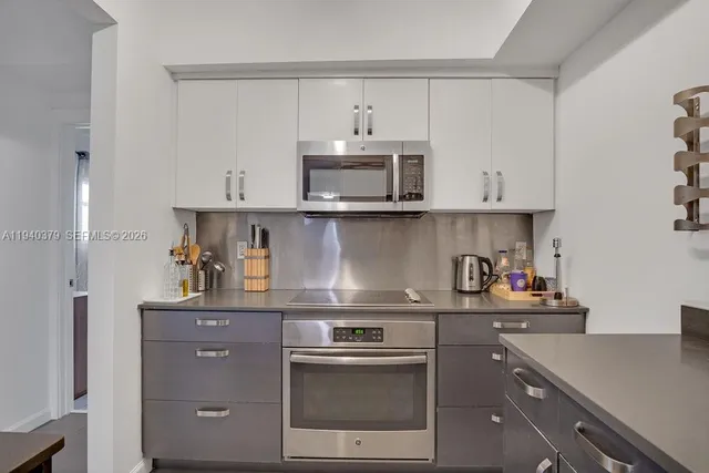 a kitchen with stainless steel appliances a sink stove and cabinets