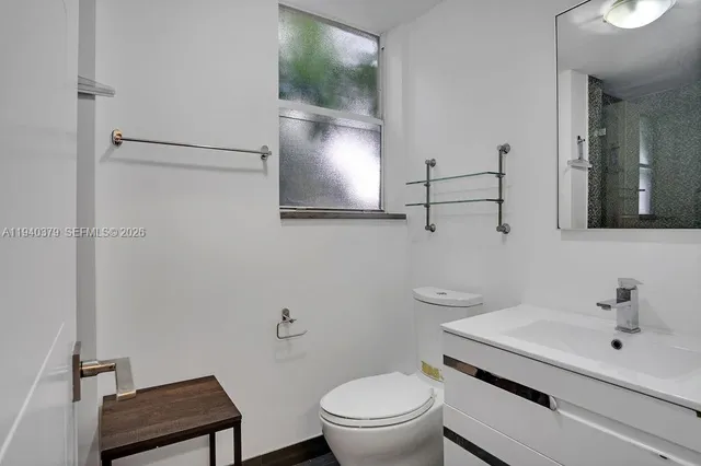 a bathroom with a toilet a sink and mirror