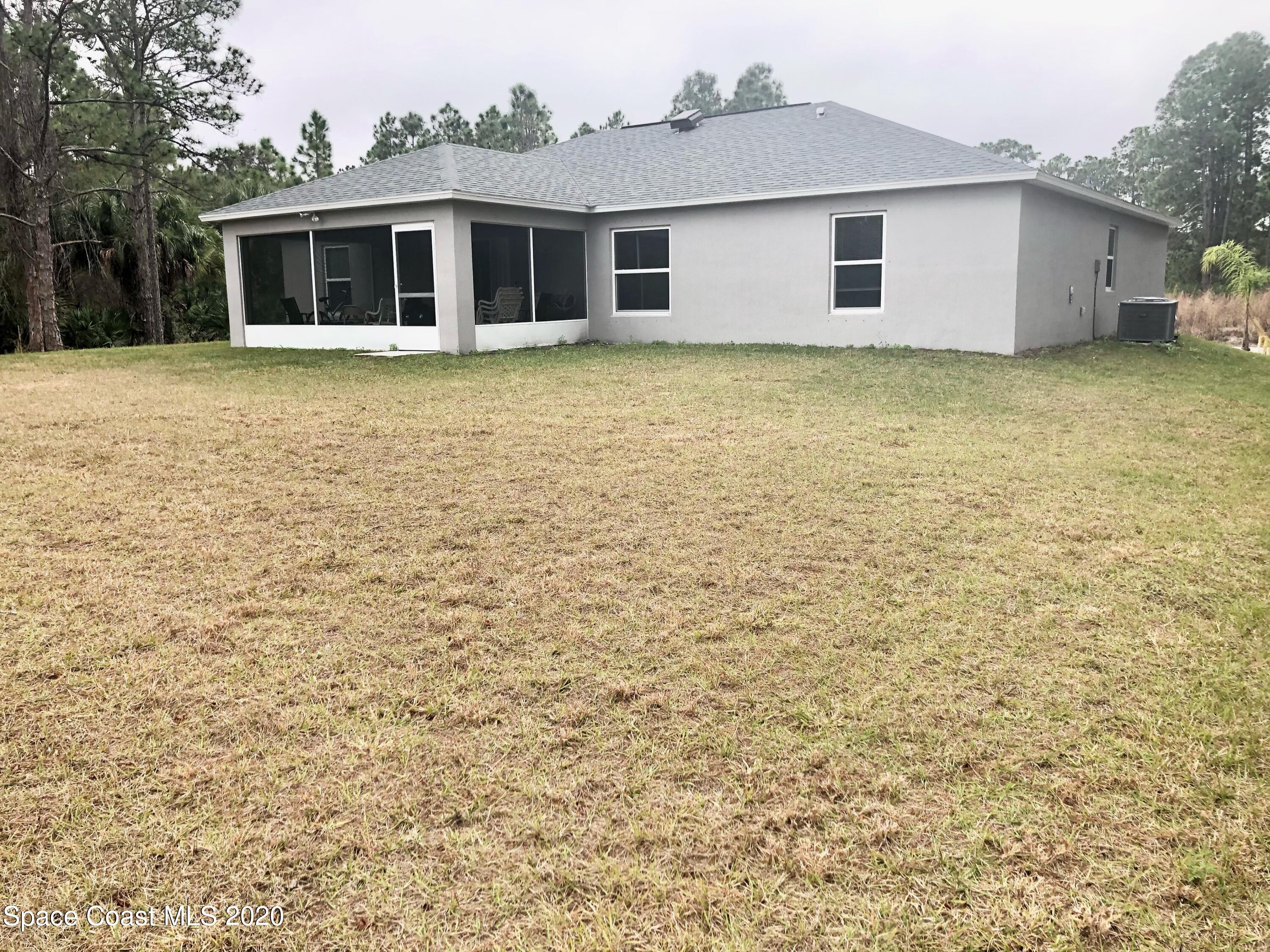 1143 Harlingen Road Southwest, Unit 32 Palm Bay, FL 32908 - Photo 3 of 11 a house that has a big yard in front of it