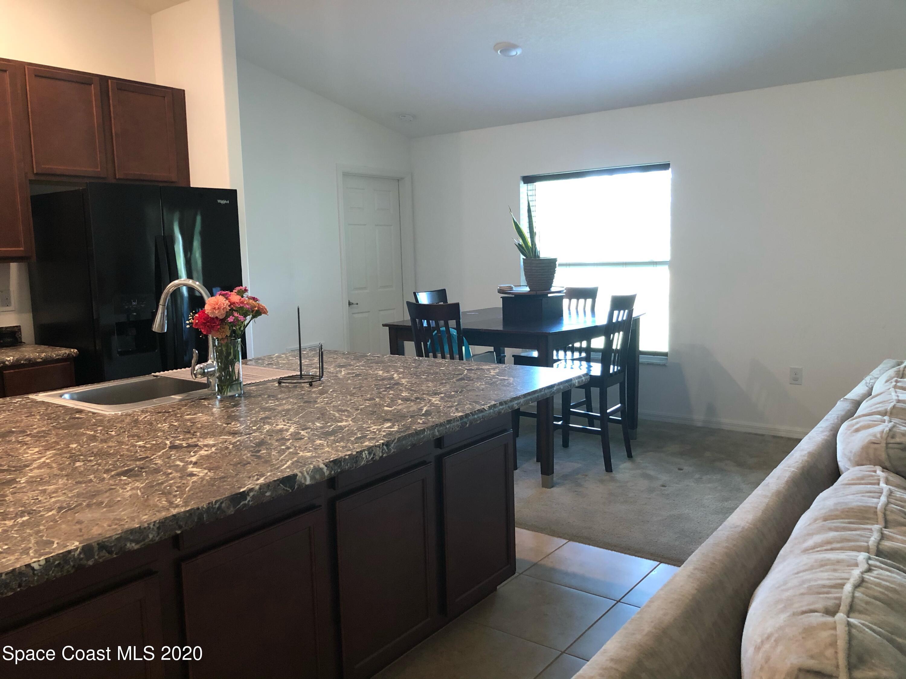 1143 Harlingen Road Southwest, Unit 32 Palm Bay, FL 32908 - Photo 6 of 11 a kitchen with a counter top space and a refrigerator