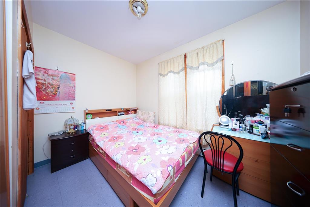 1748 79th Street Brooklyn, NY 11214 - Photo 9 of 20 a bed sitting in a bedroom next to a window