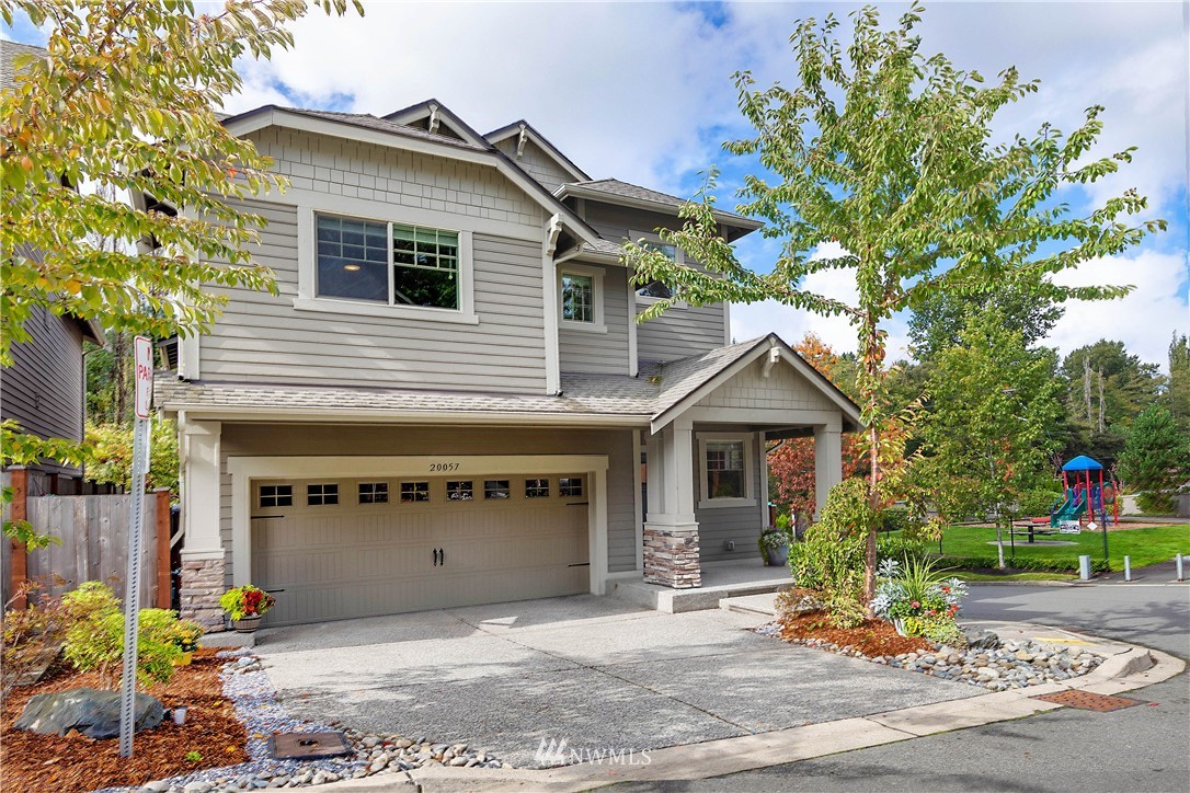 20057 94th Avenue Northeast, Unit 36 Bothell, WA 98011 - Photo 2 of 31 a front view of a house with a yard and garage