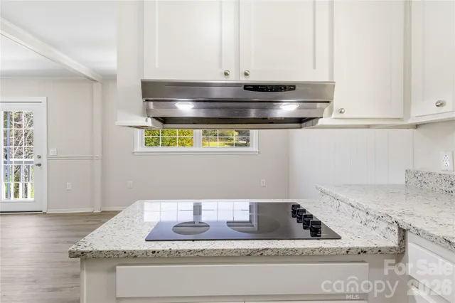 a kitchen with kitchen island granite countertop a sink and a stove
