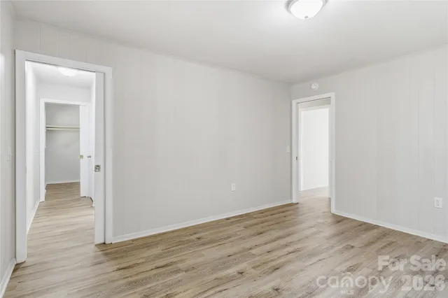 a view of an empty room with wooden floor