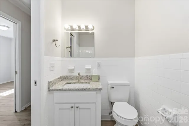 a bathroom with a granite countertop toilet sink and mirror