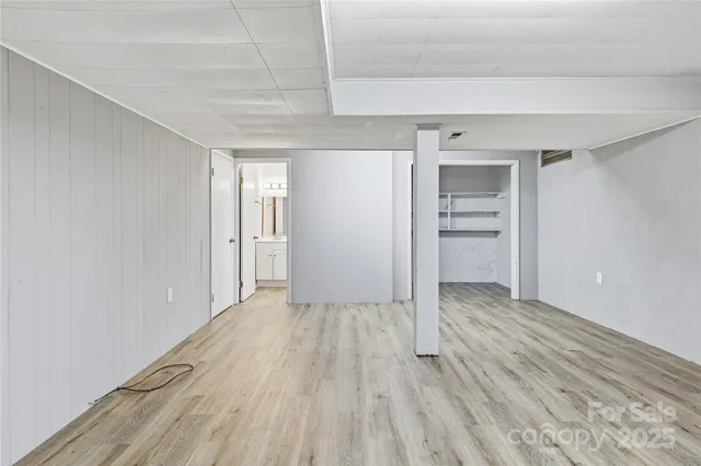 a view of an empty room with closet and a window
