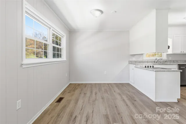 a view of a kitchen with wooden floor and electronic appliances