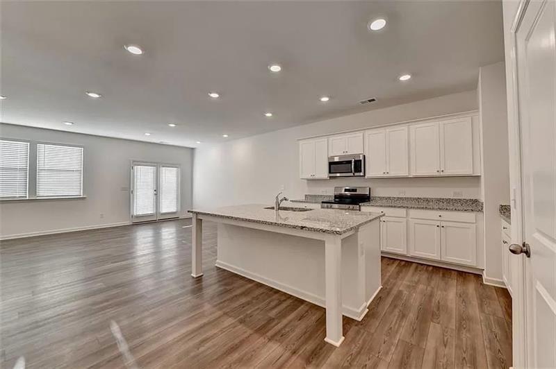 100 Mission Boulevard Pendergrass, GA 30567 - Photo 4 of 17 a kitchen with stainless steel appliances granite countertop a stove a sink and a refrigerator
