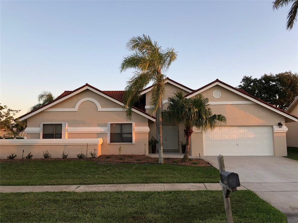 9488 Majestic Way Boynton Beach, FL 33437 - Photo 1 of 15 a front view of a house with a garden and yard