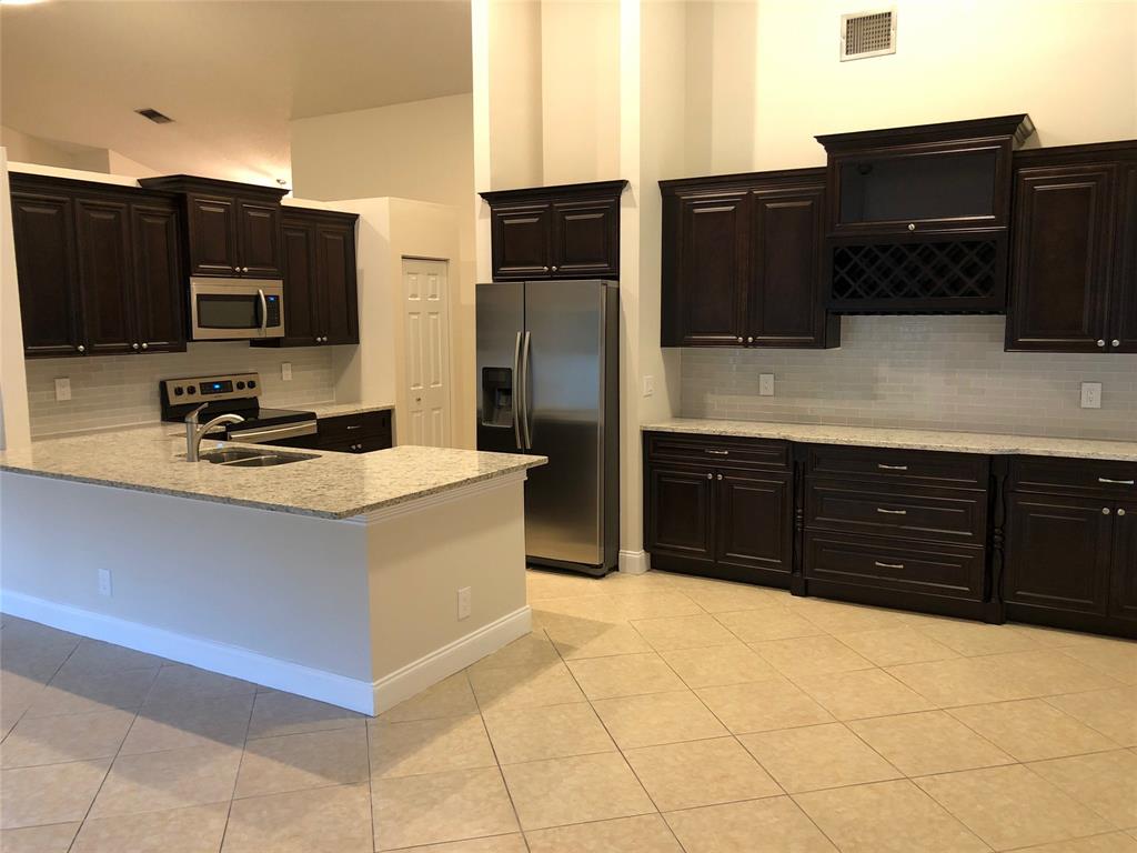 9488 Majestic Way Boynton Beach, FL 33437 - Photo 2 of 15 a kitchen with stainless steel appliances a sink and a refrigerator
